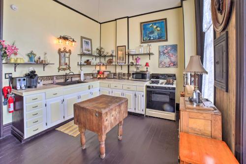 a large kitchen with white cabinets and a table at Vintage Apartment in Historic Downtown La Porte! in LaPorte