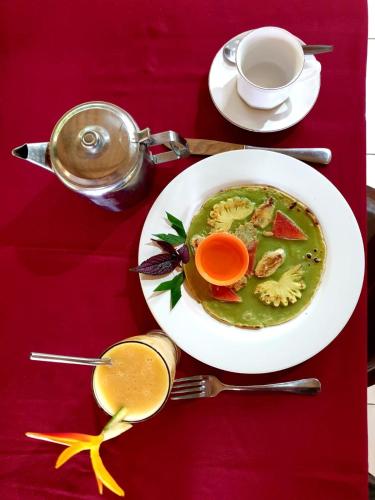 a red table with a plate of soup and a cup of coffee at Great Mountain Views Villa Resort in Sidemen