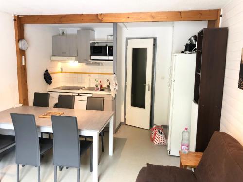 a kitchen with a table and chairs and a refrigerator at Plein coeur de Barèges, appartement 4/6 personnes in Barèges