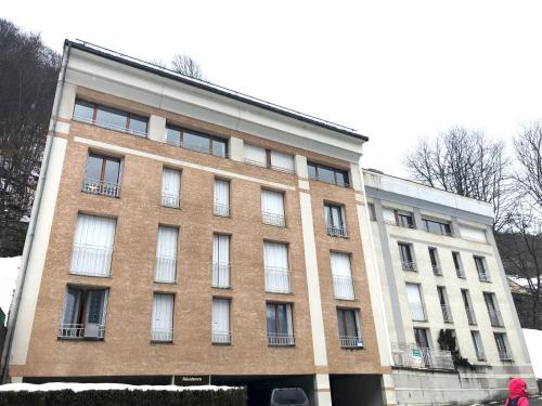 un gran edificio de ladrillo con ventanas en una calle en Plein coeur de Barèges, appartement 4/6 personnes, en Barèges