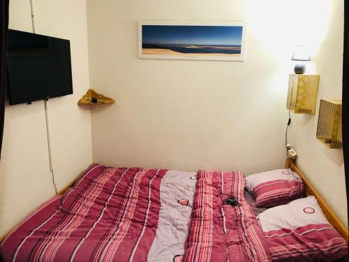 1 dormitorio con 1 cama y TV de pantalla plana en Plein coeur de Barèges, appartement 4/6 personnes, en Barèges