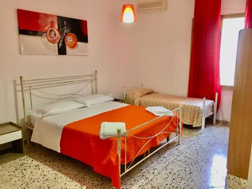 カステッルッツォにあるRiserva Monte Cofanoのベッドルーム1室(赤いカーテン付きのベッド2台付)