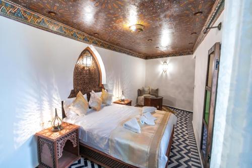 una camera con letto in una stanza con soffitto di Dar Hafsa a Fes