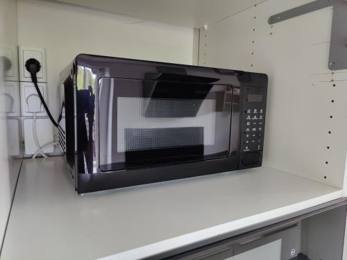 a microwave sitting on a counter in a kitchen at Bjergby Guesthouse in Hjørring