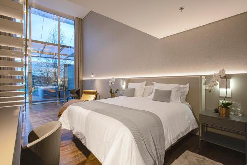 a bedroom with a large bed and a large window at Suryaa Hotel Pinhais, Curio Collection by Hilton in Pinhais