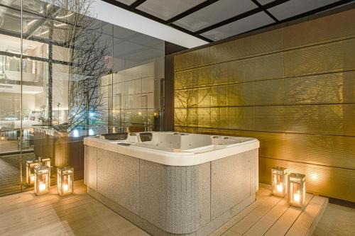 a bathroom with a tub with lights in it at Suryaa Hotel Pinhais, Curio Collection by Hilton in Pinhais