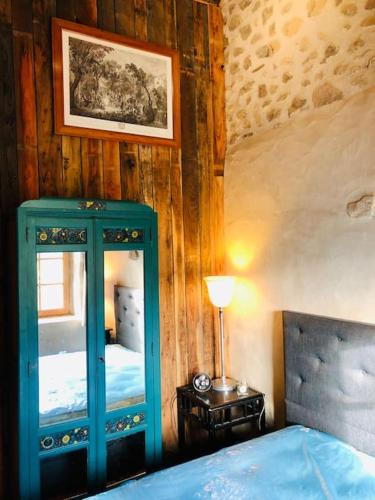 - une chambre avec un meuble bleu et un miroir dans l'établissement La petite Maison du Bonheur & Jacuzzi, à Croze