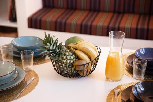 une table avec un ananas et un bol de fruits dans l'établissement Le Roi Soleil T2 en plein cœur De Ville !, à Versailles