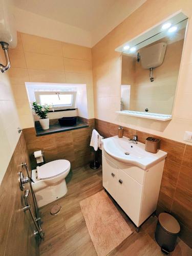 uma casa de banho com um lavatório, um WC e um espelho. em Locus Amoenus Apartment a pochi passi dagli Scavi em Pompeia