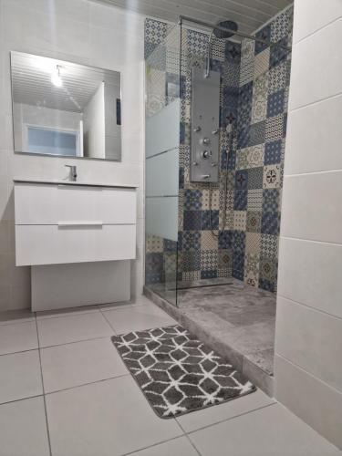 a bathroom with a shower with a glass door at Le Saint Trosepez in Sainte-Rose