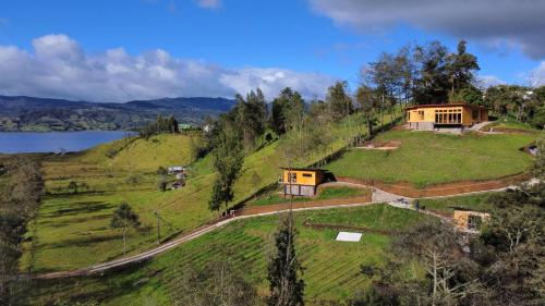 a house on top of a green hill with a lake at Villa De Los Sueños in Pasto