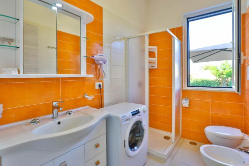 a bathroom with a washing machine and a sink at I giardini dell'Olimpo in Paestum