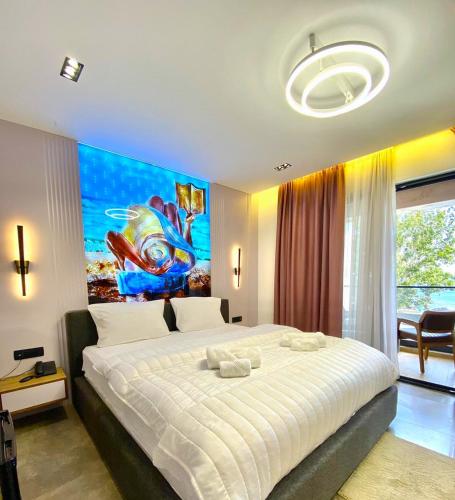 a bedroom with a large bed with a painting on the wall at Marinus Hotel in Ulcinj