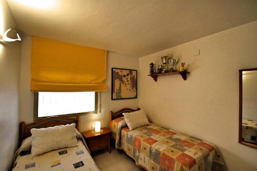 ミアミ・プラトーヤにあるARENDA Apartamento Flamencos 114の小さなベッドルーム(ベッド2台、窓付)