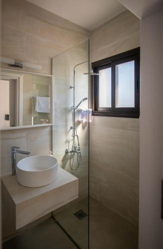 a bathroom with a sink and a glass shower at Villa Fortuna in Ayia Napa