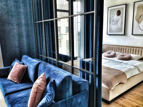 a living room with a blue couch and a mirror at IDYLLA Apartamenty w sercu Wrocławia na Ostrowie Tumskim in Wrocław