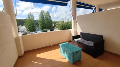 sala de estar con silla y ventana grande en Apartamentos Cala Azul La Móra en Tarragona