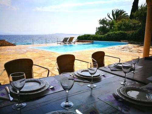 tavolo con bicchieri da vino e vista sulla piscina di Bella Vista apartments with hot pool and jacuzzi a Trogir