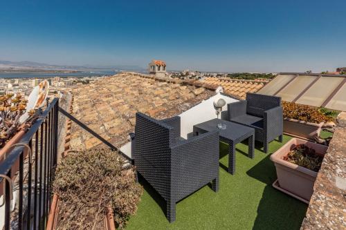 a balcony with a table and chairs on a roof at Residenza Kastrum in Cagliari