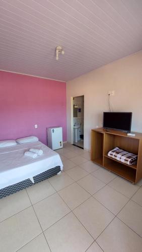 a bedroom with a bed and a tv in a room at Pouso do Rosario in Pirenópolis