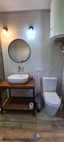 a bathroom with a sink and a toilet and a mirror at Racha Cornfield House in Oni