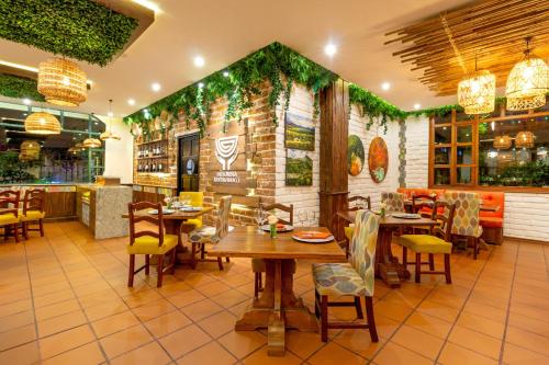 un comedor con mesas y sillas en un restaurante en La Floresta Hotel, en Baños