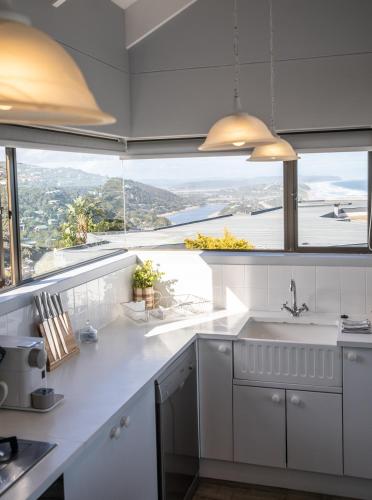 a kitchen with white counters and large windows at The Loft in Wilderness