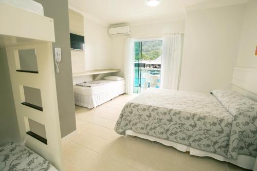 1 dormitorio con 2 camas y ventana en Parque Aquático Cascanéia, en Blumenau