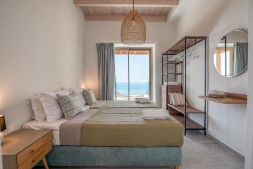 a bedroom with a bed with a view of the ocean at Alma Natura Villas Falasarna - Aposperitis Villa in Falasarna
