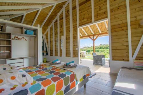 - une chambre avec un lit et une grande fenêtre dans l'établissement Cottages du Lagon, à Saint-François