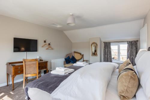 a bedroom with a bed and a desk with a computer at Luxury Farmhouse with Stunning Views and Hot Tub in Ebberston