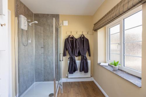 a bathroom with a walk in shower and a glass shower stall at Luxury Farmhouse with Stunning Views and Hot Tub in Ebberston