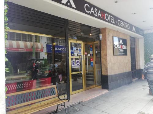 un frente de tienda con un banco delante de él en CasaHotel Centro - Huancayo en Huancayo