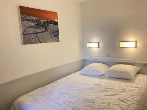ein Schlafzimmer mit einem Bett mit zwei Kissen und einem Bild in der Unterkunft Appartement 2 pièces pour 4 personnes avec Wifi à Avoriaz - FR-1-634-81 in Morzine