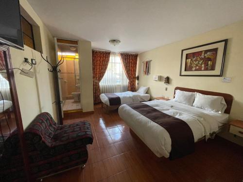 une chambre d'hôtel avec un lit et une chaise dans l'établissement CasaHotel Centro - Huancayo, à Huancayo