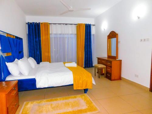 sypialnia z łóżkiem, komodą i lustrem w obiekcie SWEET BREEZE HOMES w mieście Mombasa