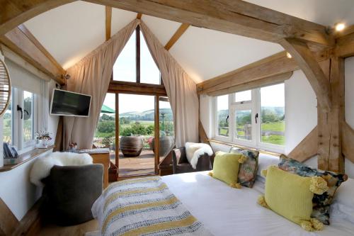 a bedroom with a large bed with a large window at Observatory at South Downs Stay in Houghton