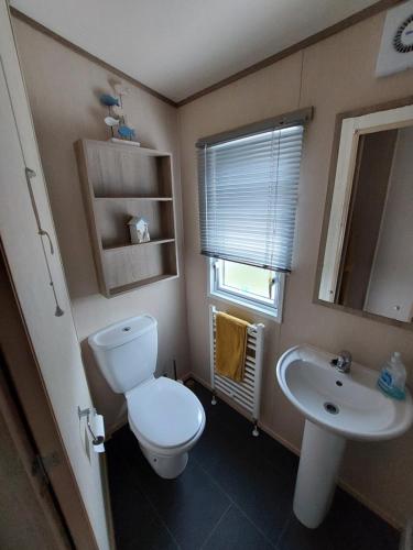La petite salle de bains est pourvue de toilettes et d'un lavabo. dans l'établissement Aurora Way 81, à Lossiemouth