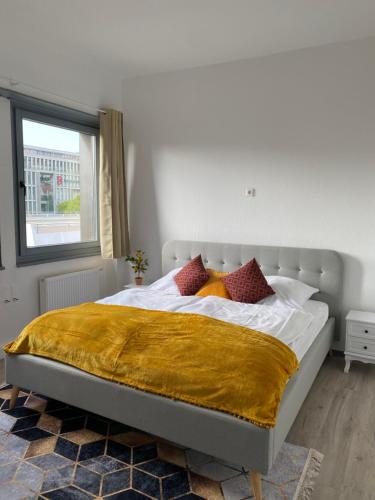 a bedroom with a bed with white sheets and red pillows at UrbanSuites - Modern & Zentral in der City - Dein Zuhause in Stuttgart in Stuttgart