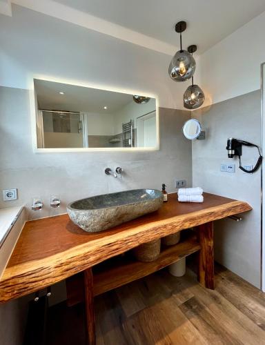 a bathroom with a stone sink and a mirror at Ferienwohnung Harzurlaub in Hahnenklee-Bockswiese