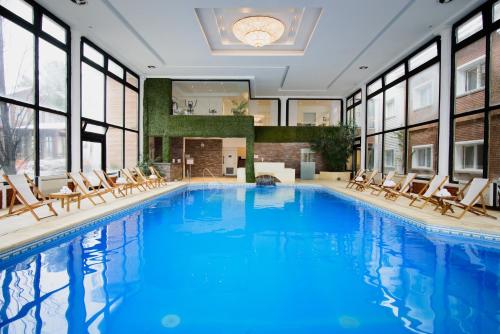 a large swimming pool with chairs in a building at Lagos Del Calafate in El Calafate
