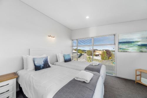a bedroom with two beds and a large window at Lake Taupo Gem in Taupo