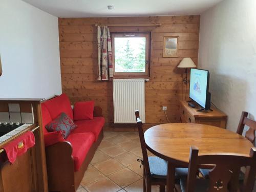 a living room with a red couch and a table at Premium Les Alpages de Chantel in Arc 1800