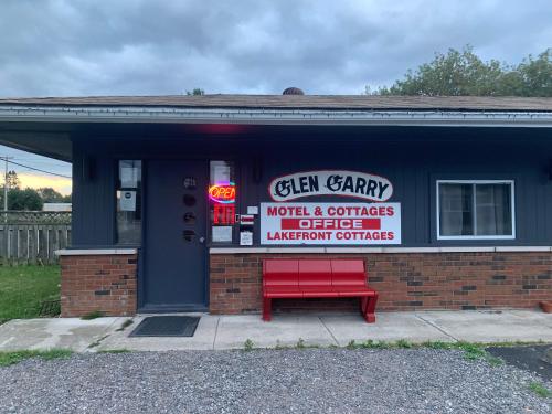 a red bench sitting in front of a building at Glen Garry motel and cottages in North Bay