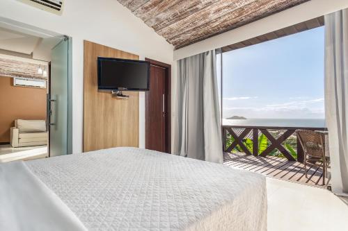 a bedroom with a bed and a view of the ocean at Costa do Sol Boutique Hotel in Búzios