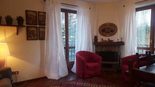 uma sala de estar com uma cadeira vermelha e uma lareira em coeur de neige em Claviere