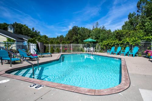 a swimming pool with blue chairs and a table at Ephraim Motel in Ephraim