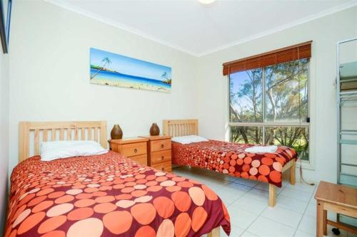 a bedroom with two beds and a window at Shiraz Cottage at Allusion in Normanville