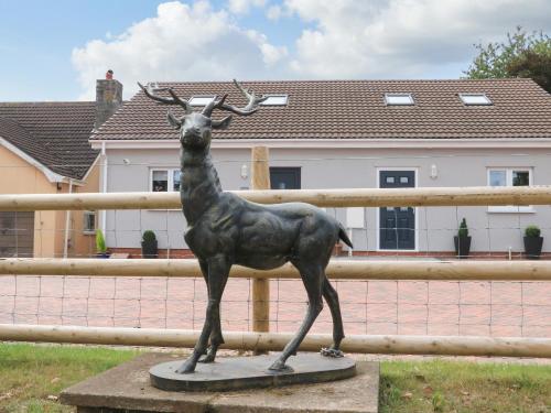 a statue of a deer in front of a fence at Sawtons Cottage 2 in Dawlish