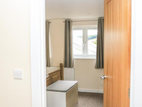 Habitación con baño con ventana y aseo. en Sawtons Cottage 2 en Dawlish